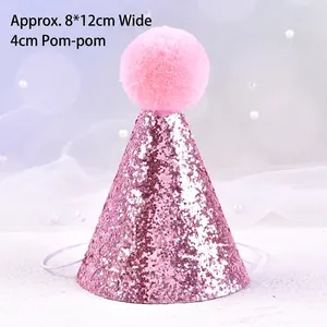 Detail view of pink glitter pet birthday hat with pom pom and elastic strap