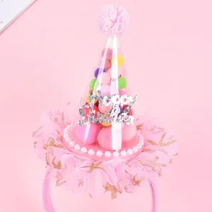 Close-up view of a pink mesh birthday party headband featuring colorful pom-poms