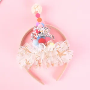 Close-up of pink birthday headband with pom-poms and Happy Birthday glitter text