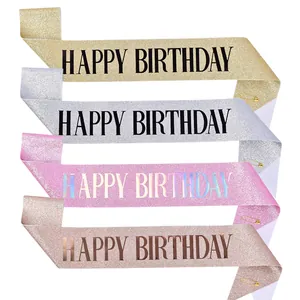 Gedetailleerde weergave van vier glitterende Happy Birthday sjerpen in goud en zilver.