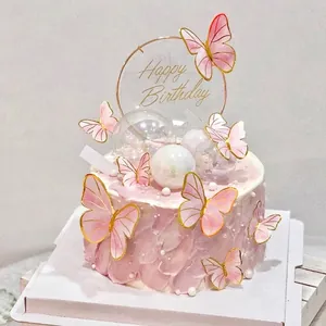 Detail of pink gold-edged butterfly cake toppers and Happy Birthday acrylic sign