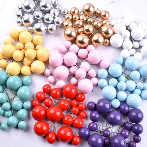 Assorted colorful foam ball cake toppers in gold silver and pastel macaron shades