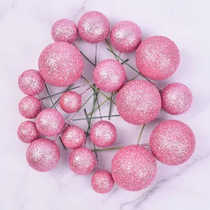 Close-up of pink glitter ball cake toppers with various sizes for party decoration