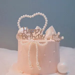Detailed view of pearl heart and bow cake toppers for elegant birthday decorations