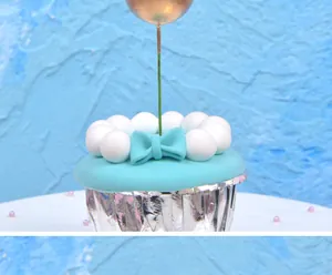 Macro view of a metallic golden sphere cake topper decoration inserted into a cupcake