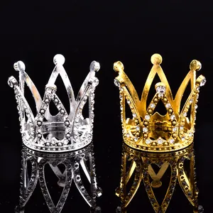 Gros plan de mini couronnes cœur en or et argent avec strass sur fond noir brillant