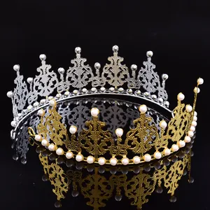 Primer plano de coronas de perlas doradas y plateadas sobre un fondo negro reflectante
