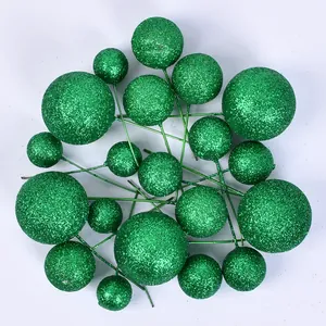 Close-up of green glitter cake topper balls in various sizes for dessert decoration
