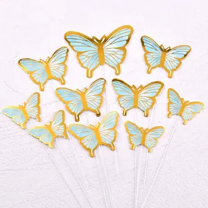 Close-up of gold and light blue butterfly cake toppers for birthday party decoration