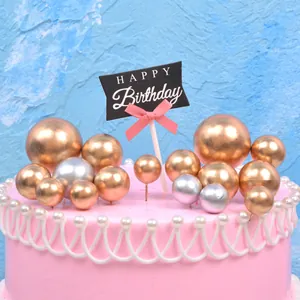 Set of shiny gold and silver sphere cake toppers with a black Happy Birthday sign topper