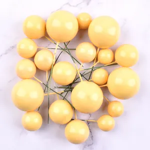 Collection of yellow macaron foam ball cake toppers scattered on marble surface