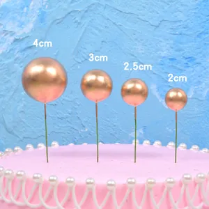 Set of rose gold sphere cake toppers in various sizes for birthday party decoration