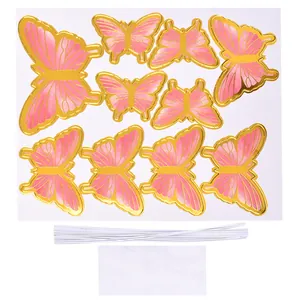 Vue détaillée des décorations de gâteau papillon rose et or avec bâtons et pastilles adhésives
