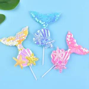 Glittering iridescent mermaid tail and seashell cake toppers for ocean themed birthday parties