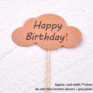 Close-up of a kraft paper cloud-shaped cake topper with Happy Birthday text and bamboo stick