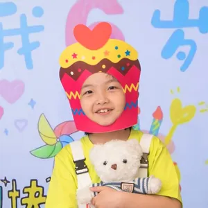 Young girl wearing a vibrant cupcake-shaped cardboard party mask for birthday photoshoot
