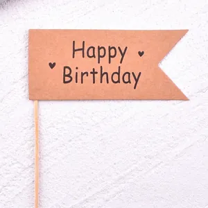 Close-up of a brown kraft paper Happy Birthday cake topper flag with dimensions