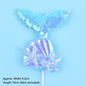 Detail view showing iridescent mermaid tail cake topper with sequins and blue starfish.