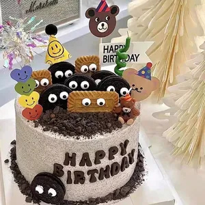 Macro detail of colorful smiley mini party hats and bear cardboard cake toppers