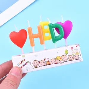 Vista dettagliata di candele colorate a forma di lettere HBD e cuori per torte di compleanno