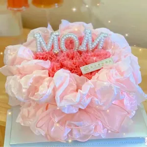 Vue détaillée du cake topper MOM en perles sur de magnifiques fleurs roses de fête