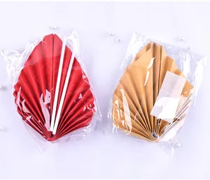 Détail des éventails en papier rétro rouge et or pour décorer les gâteaux d'anniversaire