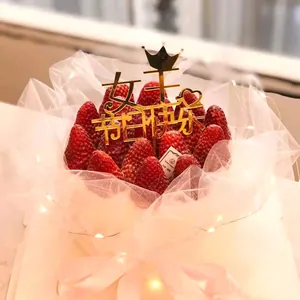Detailed shot of a gold acrylic 'Happy Queen's Day' cake topper with a crown design decoration