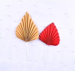 Vue détaillée d'éventails en papier plissé rouge et or pour décoration de gâteau