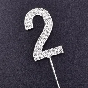 Close-up of a sparkling silver rhinestone number 2 cake topper for birthday decor