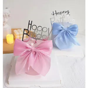 Detail view of pink and blue mesh bow cake toppers with Happy Birthday signs