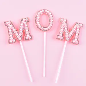 Vue détaillée de la décoration de gâteau MOM en perles roses et strass pour la fête des mères