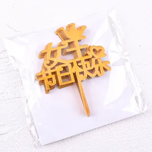 Detailed view of golden acrylic cake topper with Chinese 'Happy Queen's Day' text