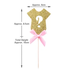 Detail view of gold glitter baby onesie cake topper with pink bow and dimensions