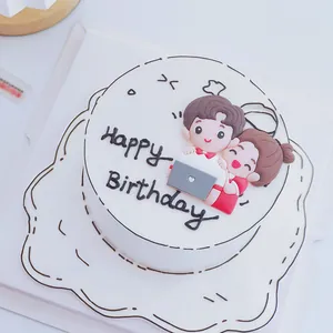 Close-up of cute cartoon boy and girl soft glue cake topper for birthday decor