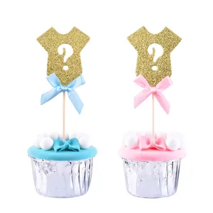 Close-up of gold glitter onesie cake toppers with decorative pink and blue silk bows