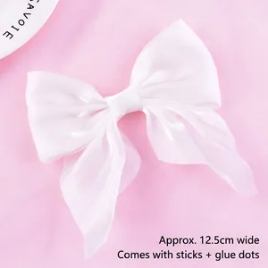 Detail of a white mesh bow cake topper, width 12.5cm with sticks and glue dots included.