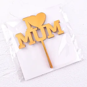 Detailed view of gold acrylic I Love Mum cake topper in clear plastic packaging