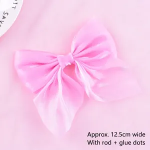 Close-up macro detail of a delicate pink mesh bow used for birthday cake decoration