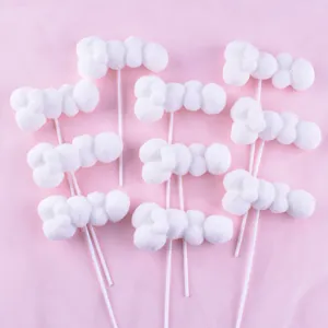 Detail of white pom-pom cloud cake toppers for birthday party decoration