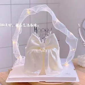 Macro view of white organza fairy ribbon cake decoration featuring warm LED lights