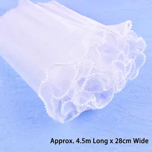 Close-up of white pleated mesh with pearl beaded scalloped edges for flower wrapping