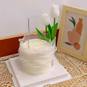 Elegant white tulip cake topper and silver candle for a romantic birthday celebration