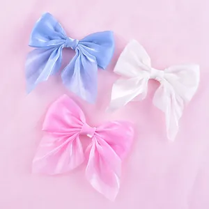 Set of three shimmery mesh fabric bow cake toppers in blue, pink, and white colors