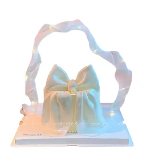 Elegant white glowing LED ribbon cake topper with bow for birthday party decorations