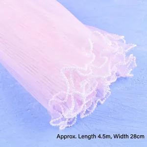 Detail view of elegant pink pleated mesh tulle with white pearl bead trim for flower wrapping