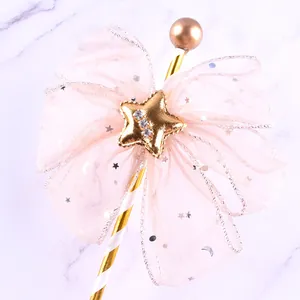 Close-up detail of a pink mesh bow cake topper with a gold star and rhinestones