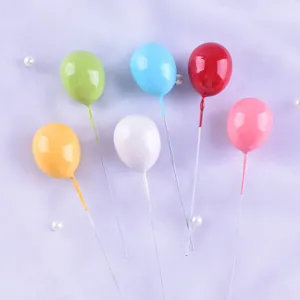 Close-up of six colorful 3D balloon cake toppers for birthday party bakery decoration