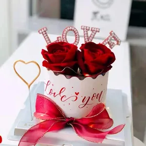 Close-up of a red rose cake topper set with pearl LOVE letters and a bow