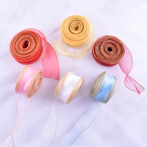 Dettaglio di nastri in organza multicolore con bordo dorato per decorazione torte e regali