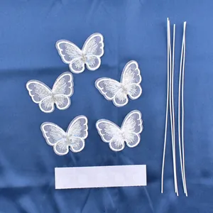 Detail of white mesh butterfly cake toppers with wire stems and adhesive dots